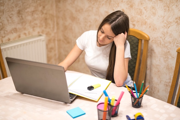 Ragazza adolescente si prepara per la classe utilizzando il suo computer portatile