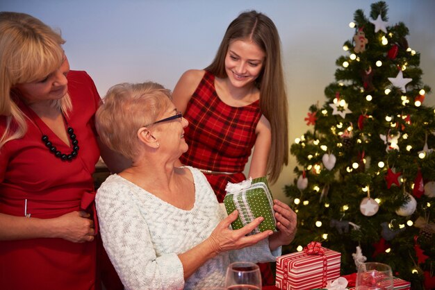 Девочка-подросток делает подарок своей бабушке