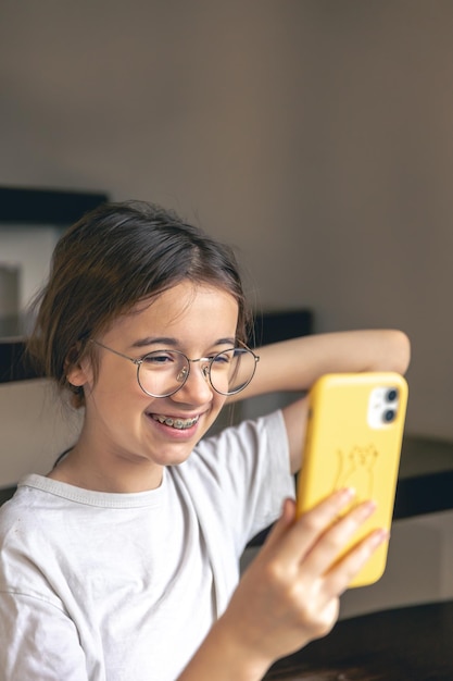 Free photo a teenage girl in glasses and braces communicates via video call