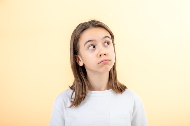 Free photo a teenage girl grimaces with displeasure on a white background isolated