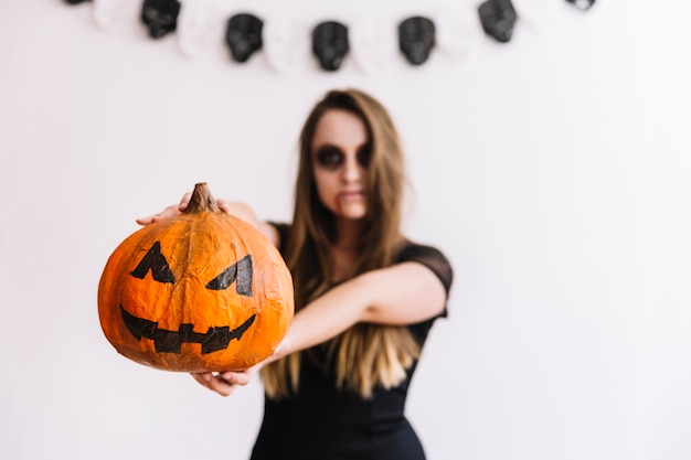 Teenage girl holding pumpkin