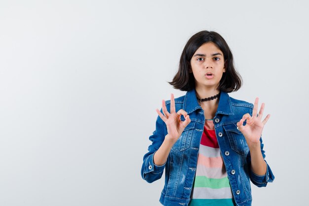 The teenage girl is showing perfect gesture with hands on white background