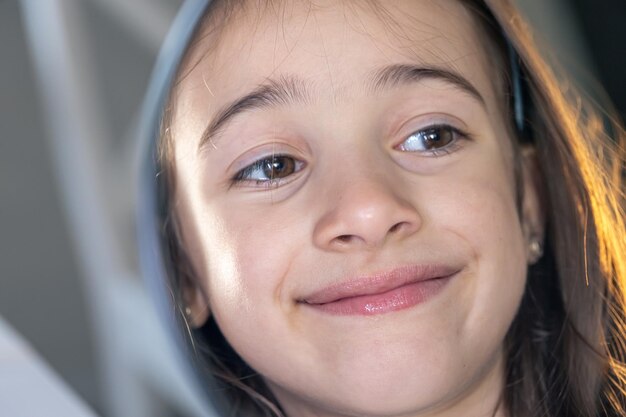 A teenage girl looks thoughtfully at her reflection in the mirror