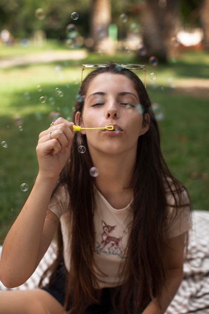 Бесплатное фото Девочка-подросток играет с мыльными пузырями
