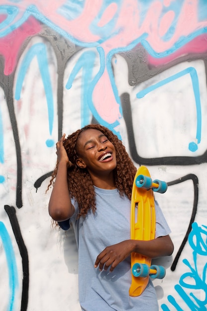 Free photo teenage girl posing at park with skateboard