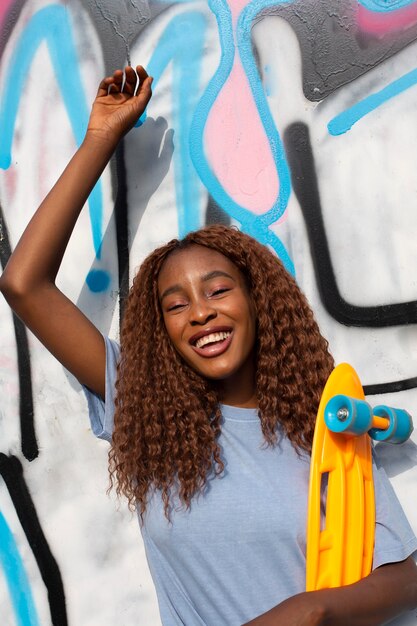 Teenage girl posing at park with skateboard