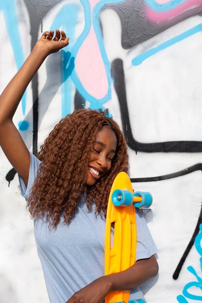 Teenage girl posing at park with skateboard