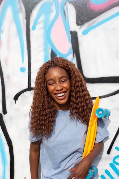 Teenage girl posing at park with skateboard
