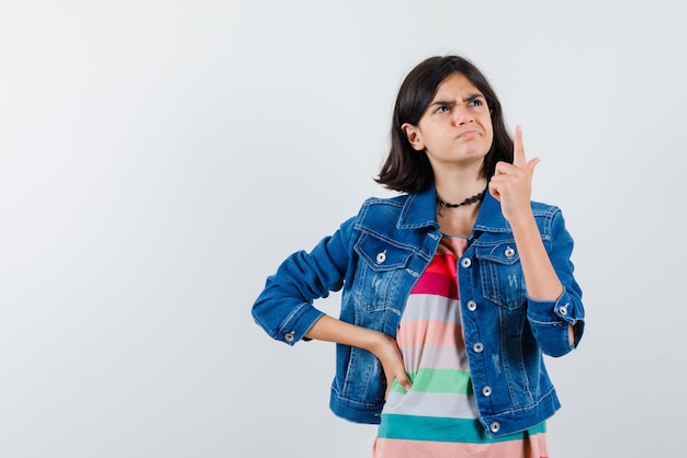 Teenage girl showing the top with finger on white background
