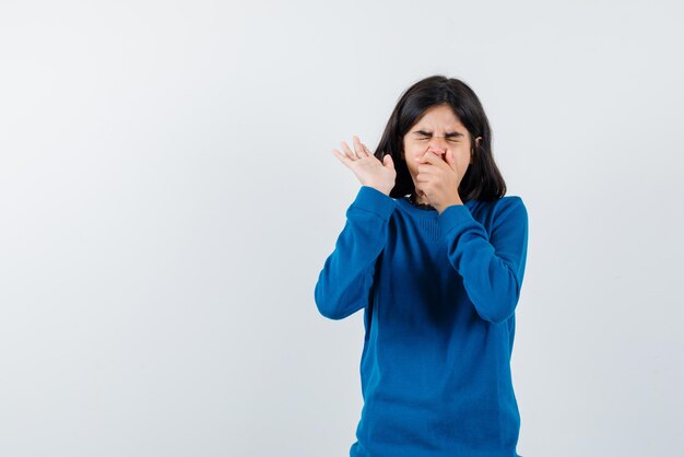 Teenage girl sneezing on white background