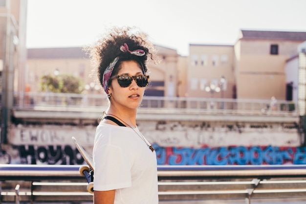 Teenage girl in sunglasses standing outside