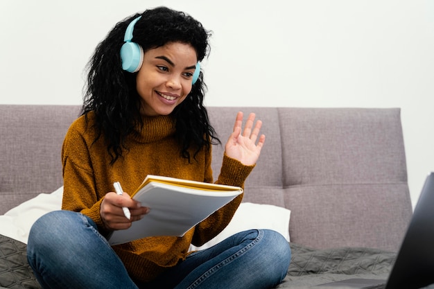 Teenage girl using laptop and headphones for online school