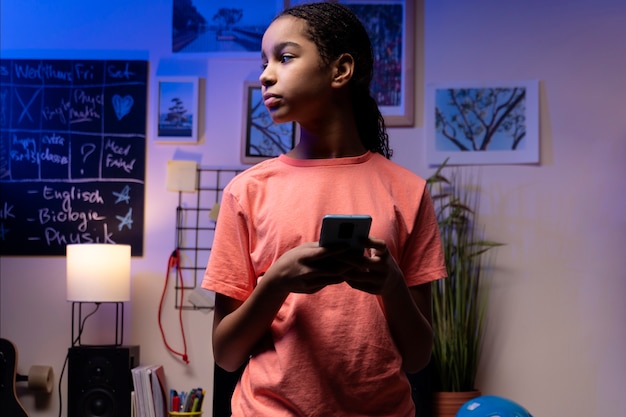 Teenage girl using smartphone at home