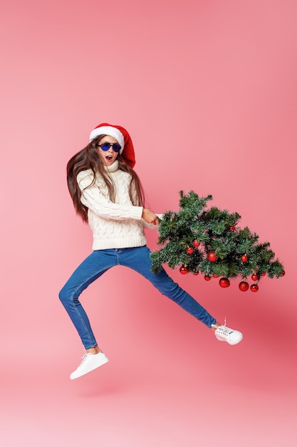 Teenage girl with a christmas tree Premium Photo