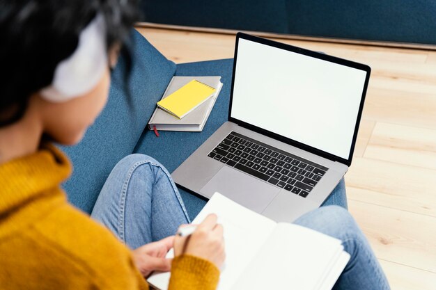 Teenage girl with headphones and laptop during online school