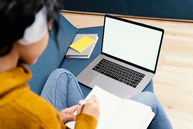 Девочка-подросток с наушниками и ноутбуком во время онлайн-школы