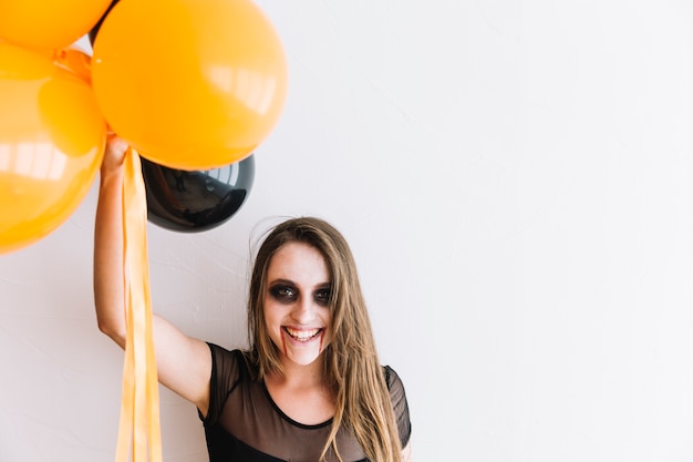 Free photo teenage girl with scary grim and black and orange air balloons