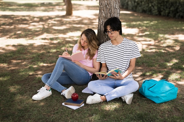 Teenage students with books in park