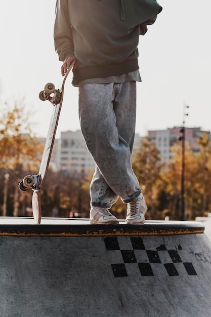 Бесплатное фото Подросток в скейтпарке позирует со скейтбордом