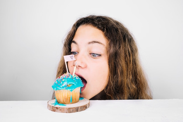 Free photo teenager biting cupcake