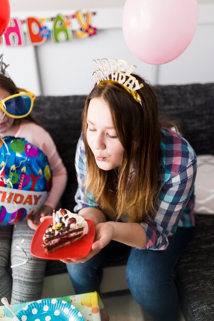 Teenager blowing candles on cake