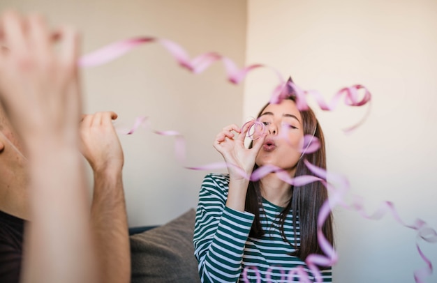 Free photo teenager blowing paper streamers