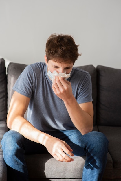 Teenager boy blowing his nose