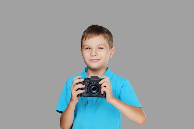 プロのカメラで写真を撮るティーンエイジャーの少年。