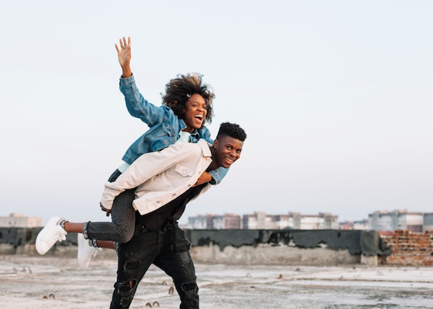 Teenager carrying young girl outdoors