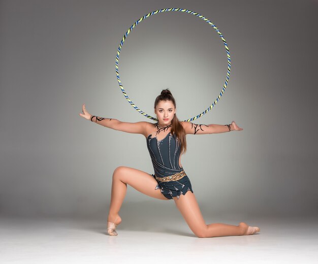 Teenager doing gymnastics exercises with colorful hoop