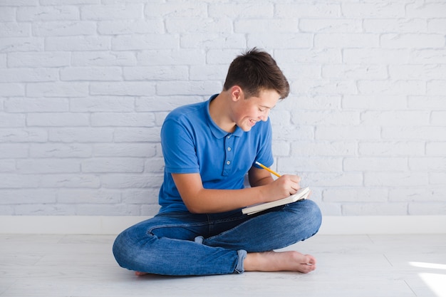 Teenager doing his homework and smiling