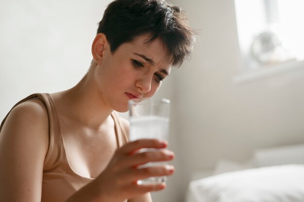 Teenager drinking medicine to reduce hangover effect