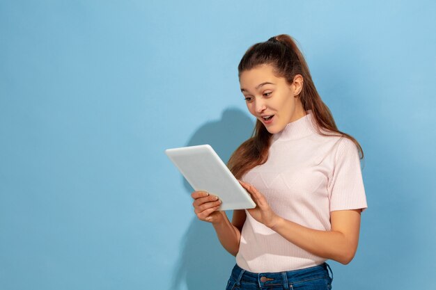 Teenager girl using tablet, astonished and shocked