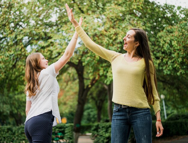 Teenager girls high five in air