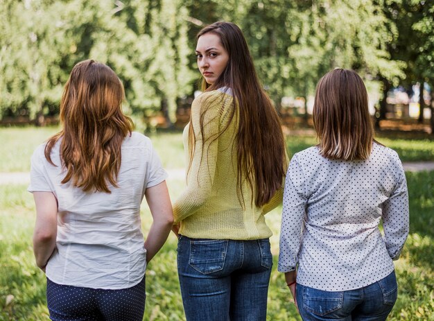 Teenager girls posing for camera with back