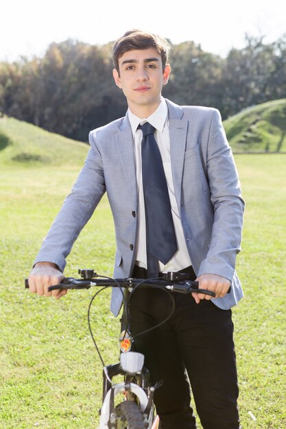 Teenager holding his bike in the garden