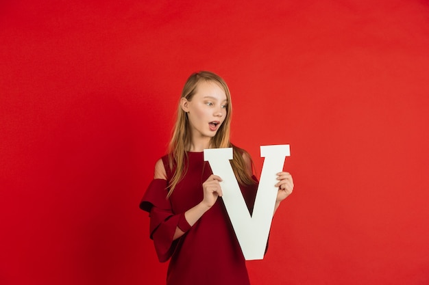 Foto gratuita adolescente che tiene la lettera v