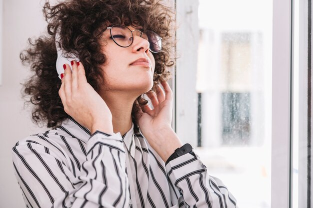 Teenager listening to music near window