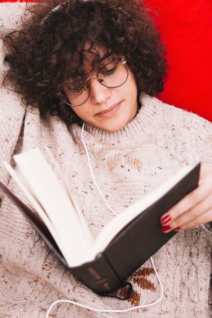 Teenager listening to music and reading book