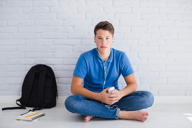 Free photo teenager listening to music wit serious face