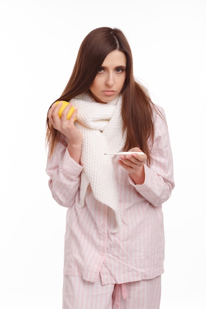 Teenager in pajamas with a thermometer