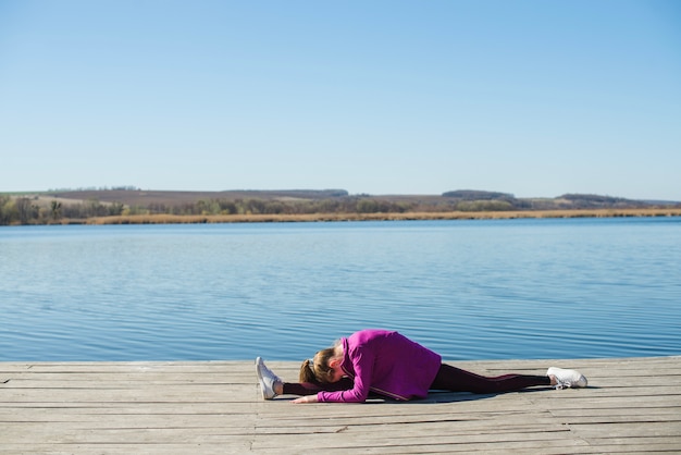 Teenager performing split on pier