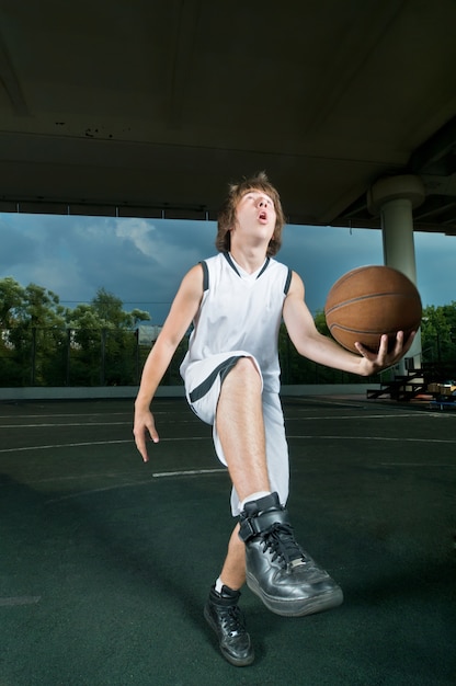 Free photo teenager playing basketball