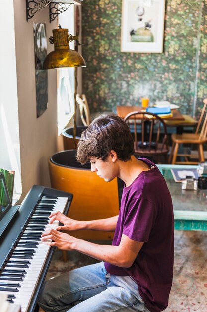 Teenager playing piano in cozy cafe