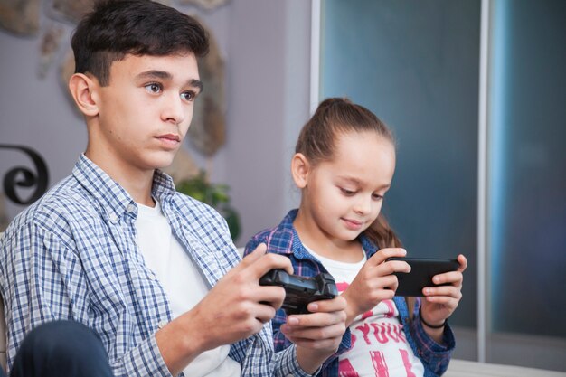 Teenager playing video games near sister