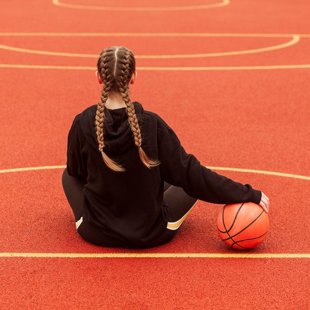 Подросток позирует на баскетбольном поле