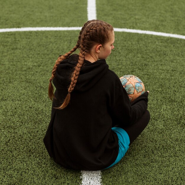 Foto gratuita adolescente in posa con una palla all'aperto