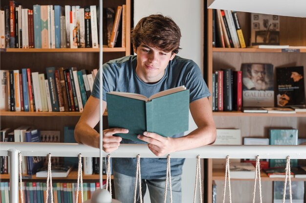 Teenager reading book in library