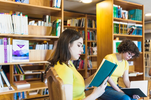 Teenager reading book near friend