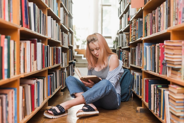 Teenager reading near backpack